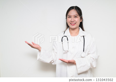 Portrait of Southeast Asian healthcare worker woman doctor in lab coat presenting something Portrait of Southeast Asian healthcare worker woman doctor in lab coat presenting something 131043502