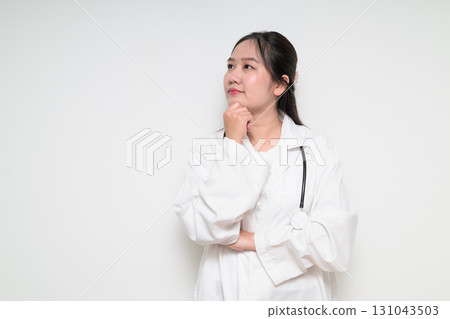 Portrait of Southeast Asian healthcare worker woman doctor in lab coat thinking Portrait of Southeast Asian healthcare worker woman doctor in lab coat thinking 131043503