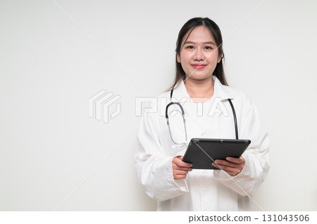 Portrait of young Asian healthcare worker woman doctor in lab coat using digital tablet computer 131043506