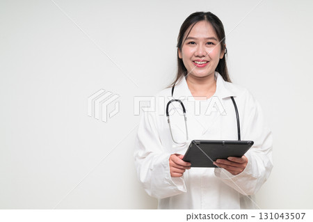 Portrait of young Asian healthcare worker woman doctor in lab coat using digital tablet computer 131043507