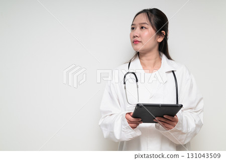 Portrait of young Asian healthcare worker woman doctor in lab coat using digital tablet computer 131043509
