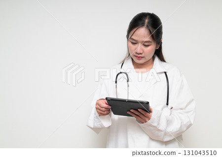 Portrait of young Asian healthcare worker woman doctor in lab coat using digital tablet computer 131043510