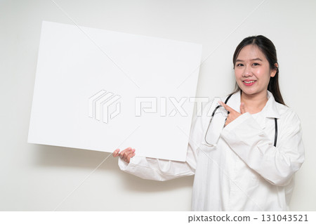 Portrait of Southeast Asian healthcare worker woman doctor in lab coat showing empty white board Portrait of Southeast Asian healthcare worker woman doctor in lab coat showing empty white board 131043521