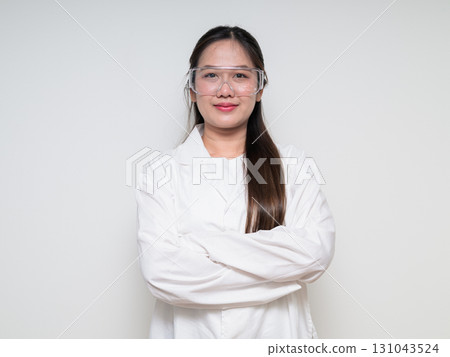 Portrait of Asian healthcare worker scientist woman in lab coat wearing safety goggle glasses 131043524