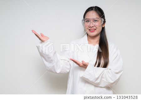 Portrait of Asian healthcare worker scientist woman in lab coat showing something Portrait of Asian healthcare worker scientist woman in lab coat showing something 131043528