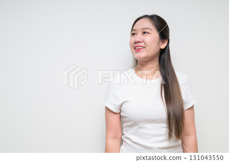 Portrait of young Asian woman thinking and looking up against white background Portrait of young Asian woman thinking and looking up against white background 131043550
