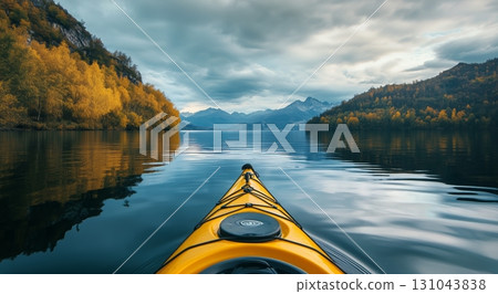 Kayaking on a Serene Lake Surrounded by Mountains and Autumn Trees in Cloudy Weather 131043838
