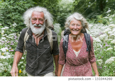 Elderly couple hiking together on a nature trail surrounded by wildflowers and greenery Elderly couple hiking together on a nature trail surrounded by wildflowers and greenery 131044260
