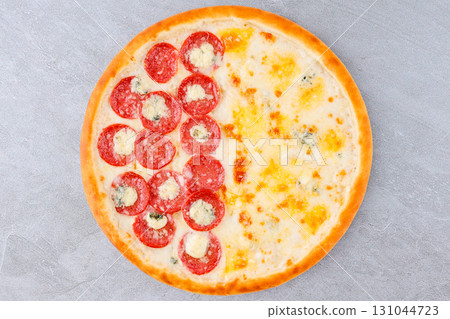 Half Pepperoni and Half Four Cheese Pizza with Blue Cheese, Mozzarella and Golden Crust on Gray Stone Background Half Pepperoni and Half Four Cheese Pizza with Blue Cheese, Mozzarella and Golden Crust on Gray Stone Background 131044723