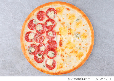 Half Pepperoni and Half Four Cheese Pizza with Mozzarella, Blue Cheese and Golden Crust on Gray Stone Background Half Pepperoni and Half Four Cheese Pizza with Mozzarella, Blue Cheese and Golden Crust on Gray Stone Background 131044725