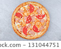 Pizza with Ham, Chicken, Fresh Tomato Slices, and Melted Cheese on Golden Crust over Gray Stone Background 131044751