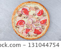 Pizza with Chicken, Mushrooms, Red Onion Rings, Tomato Slices, and Melted Cheese on Gray Stone Background 131044754