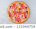 Pizza with Bacon, Pepperoni, Mushrooms, Tomato Slices, Black Olives and Melted Cheese on Stone Background 131044758