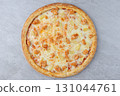 Hawaiian Style Pizza with Pineapple Chunks, Chicken Pieces and Melted Cheese on Baked Crust over Gray Stone Background 131044761