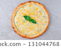 Italian Four Cheese Pizza with Basil Leaves, Melted Mozzarella and Parmesan on Baked Crust over Gray Stone Background 131044768