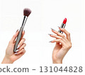 Close-up of hands applying red lipstick with makeup brush on clean white background. Perfect for beauty tutorials, cosmetic ads, and salon marketing materials 131044828