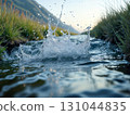 Dynamic water splash in mountain lake with droplets capturing motion. Perfect for beverage ads, outdoor brands, and refreshing summer campaign visuals.  131044835