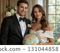 Elegant couple in formal wear holding globe with floral backdrop by large windows. Ideal for wedding magazines, luxury brands, and romantic decor. Symbolizes love and worldly connection 131044858