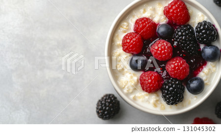 Creamy oatmeal bowl topped with vibrant berry jam and fresh fruit Creamy oatmeal bowl topped with vibrant berry jam and fresh fruit 131045302