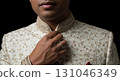 Blank wedding ring barely visible, adjusting sherwani collar, isolated 131046349
