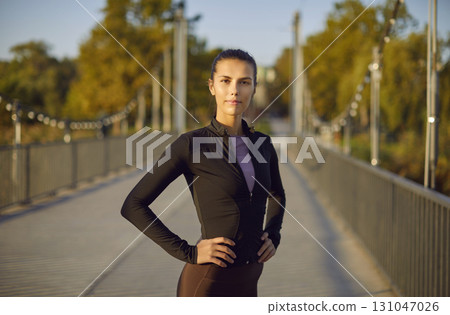 Portrait of sporty woman standing outdoors in the park and looking at camera. Portrait of sporty woman standing outdoors in the park and looking at camera. 131047026