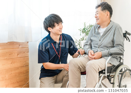 Senior male patient in a wheelchair and male caregiver/care manager staff (dementia/rehabilitation) 131047035