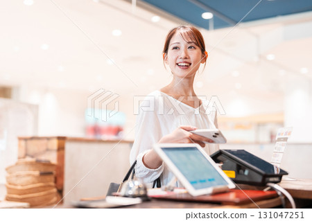 Cashless smartphone payment young woman 131047251