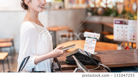 Cashless smartphone payment young woman 131047255