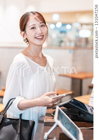 Cashless smartphone payment young woman 131047256