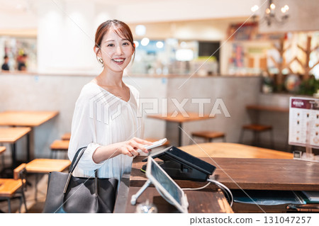 Cashless smartphone payment young woman 131047257