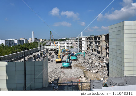 Aged public housing to be demolished Work scene of dismantling with large heavy machinery 131048311