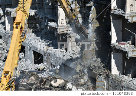 Aged public housing to be demolished Work scene of dismantling with large heavy machinery 131048398