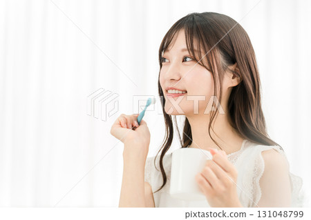 Young Asian woman brushing her teeth at home (cosmetic dentistry, whitening, dental care) Young Asian woman brushing her teeth at home (cosmetic dentistry, whitening, dental care) 131048799