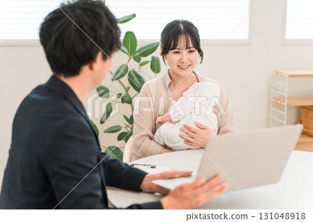 一位母親抱著嬰兒,在上門推銷時聽取推銷員的建議,一位女性顧客 一位母親抱著嬰兒,在上門推銷時聽取推銷員的建議,一位女性顧客 131048918