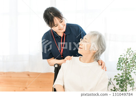 Senior female patient in a wheelchair and female caregivers and care managers (day care center, nursing home) 131049784