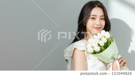 Smiling woman holding a bouquet of white tulips 131049926