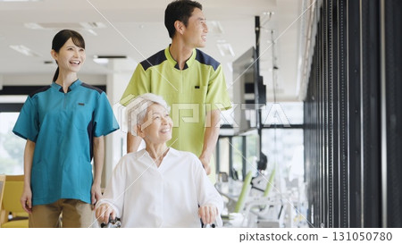 Elderly people and caregivers walking in wheelchairs Elderly people and caregivers walking in wheelchairs 131050780