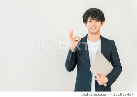 A young man of the digital native generation holding a computer (ok, recommended, successful, established, nice) 131052494