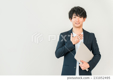 A young man of the digital native generation holding a computer (trust, security) A young man of the digital native generation holding a computer (trust, security) 131052495