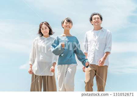 Three parents and children walking under the blue sky (family trip, family, father, mother, daughter) 131052671