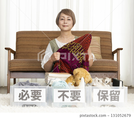 Senior woman decluttering in the living room Senior woman decluttering in the living room 131052679