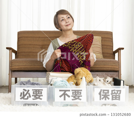 Senior woman decluttering in the living room Senior woman decluttering in the living room 131052680