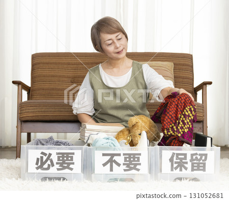 Senior woman decluttering in the living room Senior woman decluttering in the living room 131052681