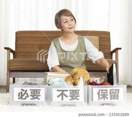 Senior woman decluttering in the living room Senior woman decluttering in the living room 131052689