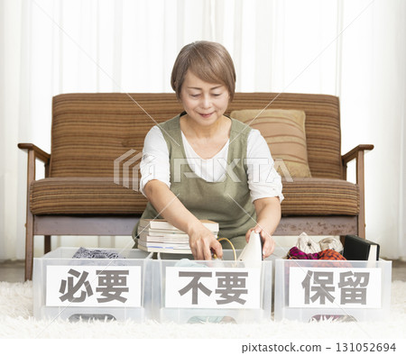 Senior woman decluttering in the living room Senior woman decluttering in the living room 131052694