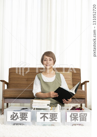 Senior woman decluttering in the living room Senior woman decluttering in the living room 131052720
