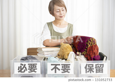 Senior woman decluttering in the living room 131052733