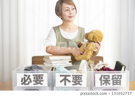 Senior woman decluttering in the living room Senior woman decluttering in the living room 131052737