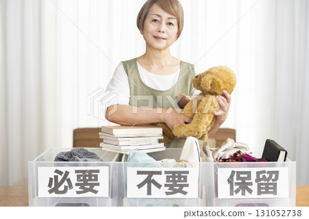 Senior woman decluttering in the living room Senior woman decluttering in the living room 131052738