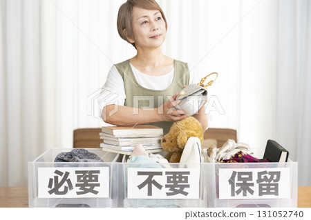 Senior woman decluttering in the living room Senior woman decluttering in the living room 131052740